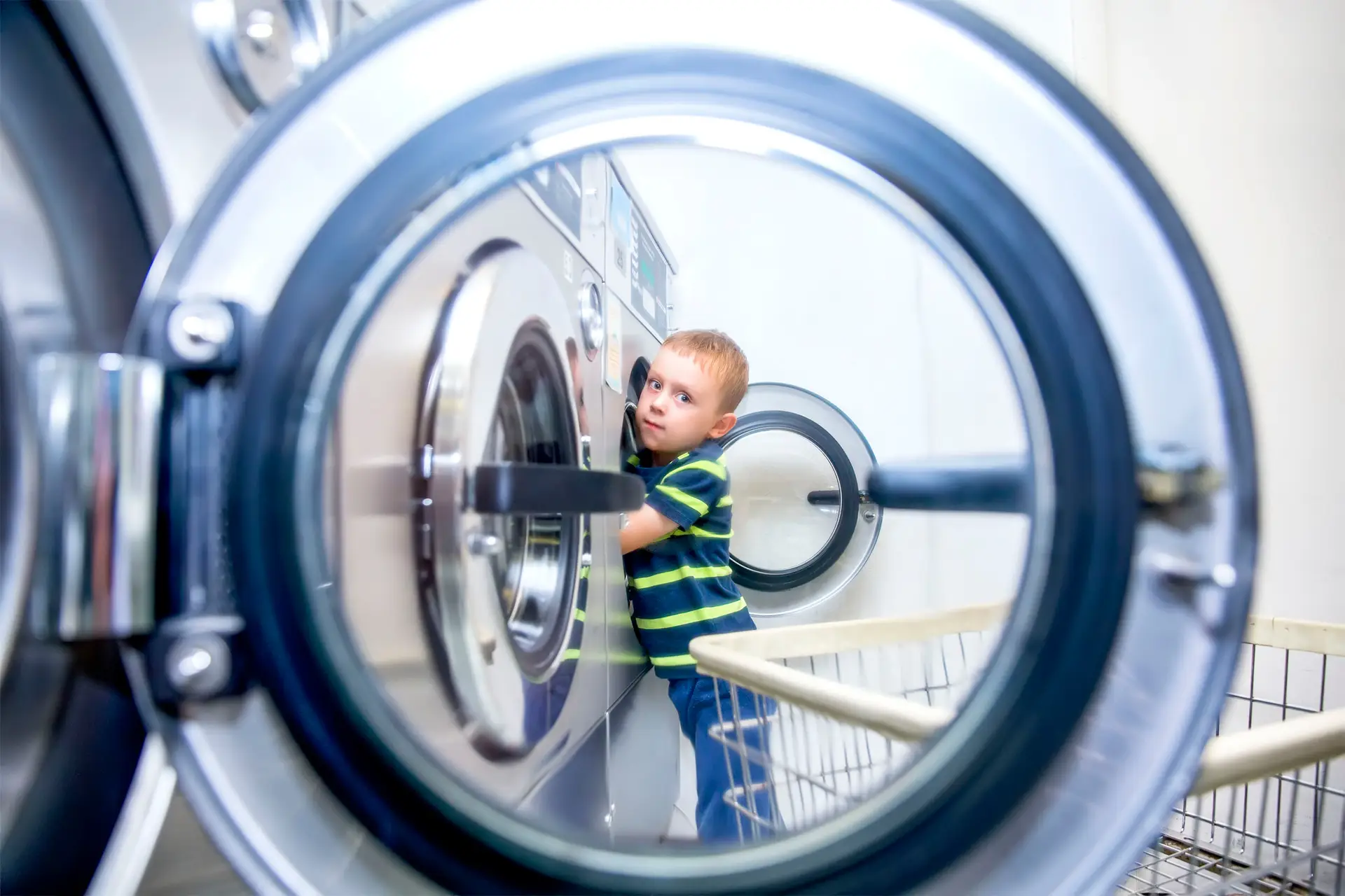 a boy looking through a washing machine
